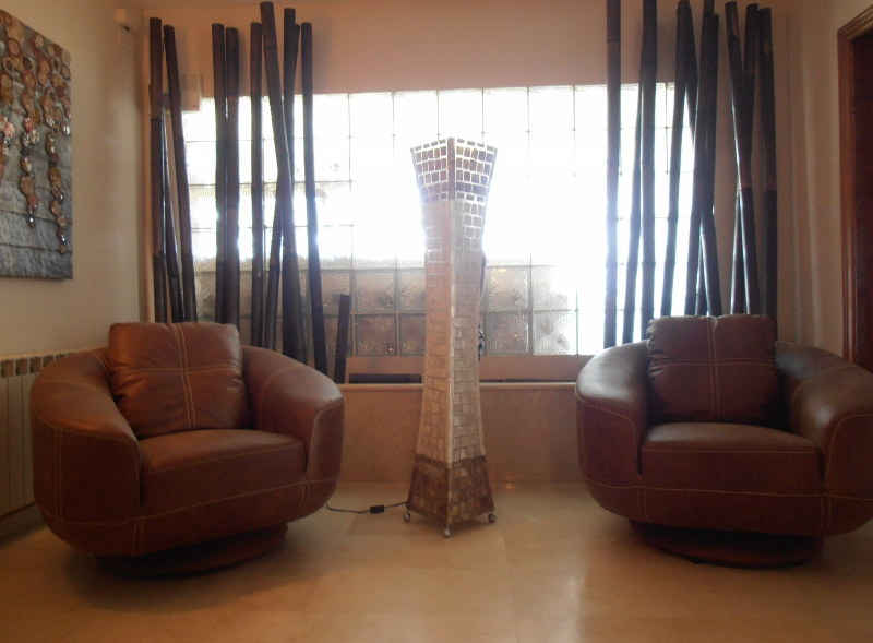 Sala de estar con sillones de cuero y lámpara de mosaico